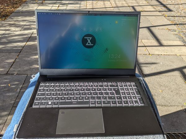 Tuxedo Aura 15 laptop on lap outside in the park